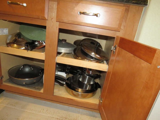 mixed cookware in kitchen cabinet
