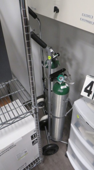 Oxygen tank carts with gauges and regulators.  Bottles appear to be rental units.