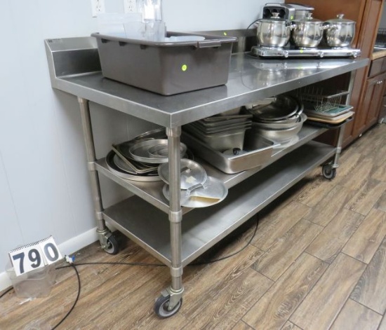 stainless steel table 72" long x 30" x 37" high comes with 2 under shelves And mounted on casters