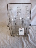 WIRE BOTTLE CARRIER WITH 6 TALL 1 QT BOTTLES. BOTTLES ARE MARKD 0.I.G.-48