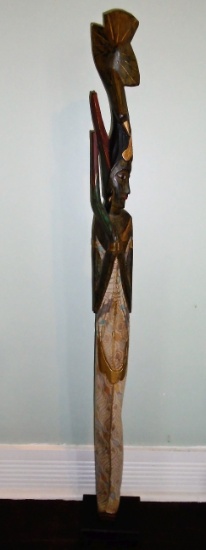 Wood carved standing woman statue with bird on her head.