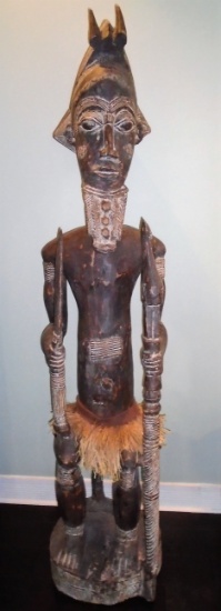 Tall standing Wood carved African Male statue with grass skirt.