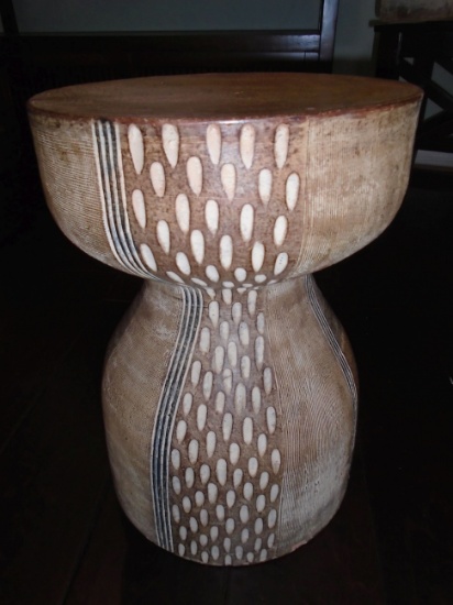 Ceramic pedestal/stool with carved design.