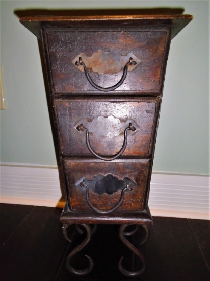 Small wooden chest of drawers with metal legs, handles and details.