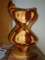 Large curvy shaped wood sculpture on a wood base.
