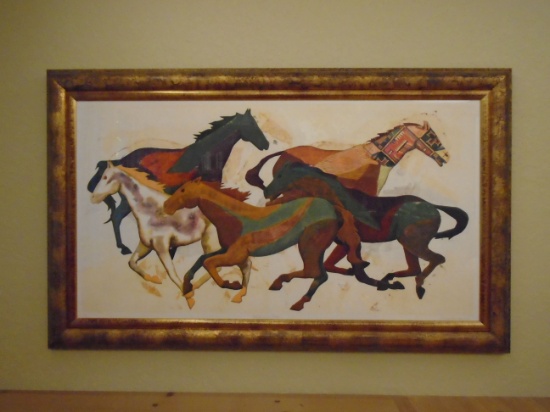 "Wild and Free" wall art of horses in a gold frame.