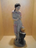 Porcelain figurine, woman warming her hands by a fire