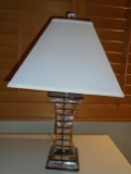 Lucite table lamp with off white lamp shade.