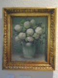 Oil painting of flowers in a gold frame.