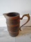 Antique wooden pitcher with metal handle.