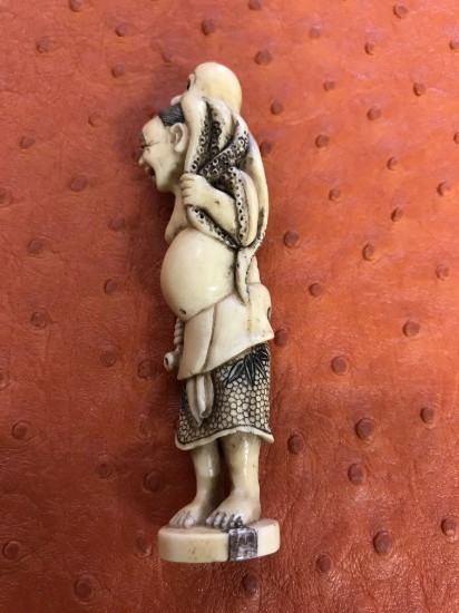 Antique Chinese timeless beautifully designed small ivory bone carved figurine of a fisherman carryi