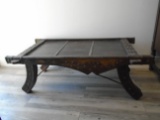 Antique wooden bench with riveted metal details.
