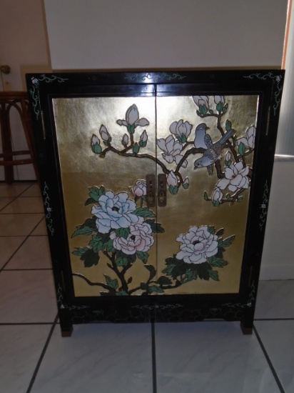 Black and gold painted cabinet with floral and bird motif.