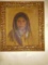 Oil painting in a gold frame. Depicts a native looking woman