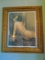 painting of a nude woman putting on lipstick, in a frame.