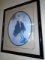 Etching in a black frame. Depicts a woman in a black dress holding a hat. by Louis Icart.