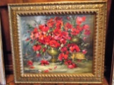 Oil painting of flowers in a vase, in a gold frame.