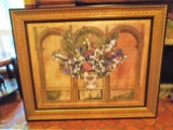 Oil painting of flowers in a vase with archway background, in a gold & black frame.