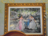 Oil painting of 3 elegantly dressed woman around a table, in a gold frame.