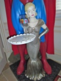 Sculpture of a woman holding a tray with a Marilyn Monroe wine glass.