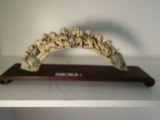 Carved and etched hippo ivory Sculpture of many dogs laying on a branch.