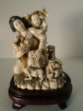 Carved and etched hippo ivory Sculpture of a woman kneeling with a child and 5 dogs