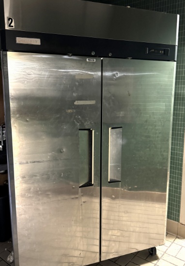 Two door stainless steel reach in freezer with three adjustable interior shelves on casters