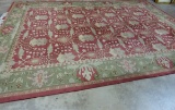 LARGE ORIENTAL  STYLE RUG, RED GROUND WITH GREEN BORDER (14' X 10')