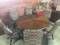 ROUND MAHOGANY TABLE AND 8 CHAIRS FLAME STITCH UPHOLSTERED BACK AND SEAT, CURVED WOODEN ARMS