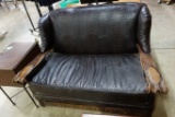 FAUX ALIGATOR COVERED LOVESEAT WITH CARVED WOOD ARMS