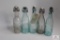 Five squat Pennsylvania clear soda bottles including porcelain bottle stops