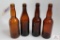 Four amber crown top beer bottles including MD, OH, NY