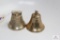 Two medium brass colored bells, one eagle pattern