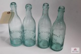 Four squat clear soda bottles including VA, NY, NJ