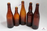 Five amber Pennsylvania crown top beer bottles