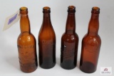 Four amber crown top beer bottles including MD, OH, NY