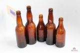 Five amber crown top beer bottles including MD, NY, WI