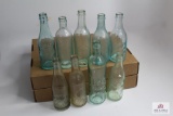 Nine blue and clear glass antique beer bottles