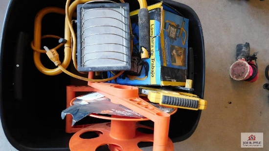 Crate of measuring tape, work light, and hose reel