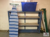 Lot: blue shelf, ironing board, blue tote, items in corner