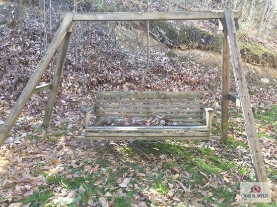Wooden swing with frame and concrete fountain