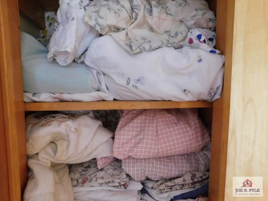 Contents of closet - stained glass shelf, bed linens, decorative items