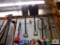 lot of hand tools on wall: rakes, shovels, pitchfork, etc.