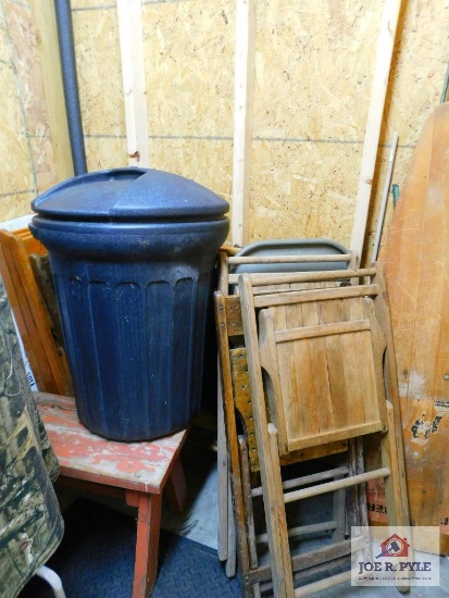 metal folding table, wooden folding chairs, bench, vintage iron board, and trash can with lid