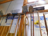 lot of hand tools on wall: rakes, shovels, hoes, etc.