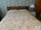 Full size bed, small table and lamp