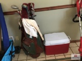 Set of golf clubs and cooler