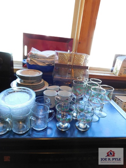 Collection of Christmas dishes and glasses with linens and candleholders