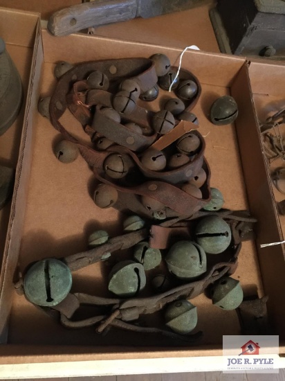Tray of horse bells. Leather strap is broken in several places