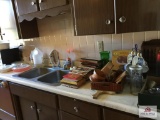 Contents of sink side of kitchen: microwave, dishes, cookbooks, flatware, etc.